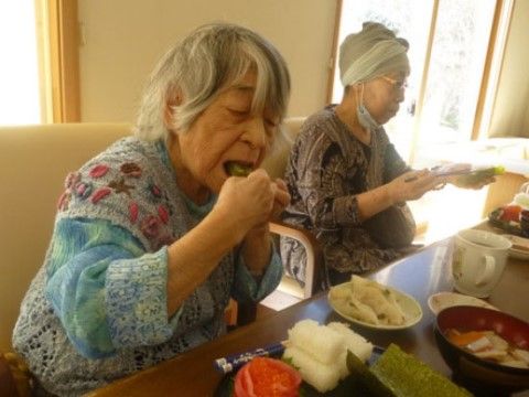 椅子に座り並んでお膳に盛り付けられた食事を摂る、二人の入居者様