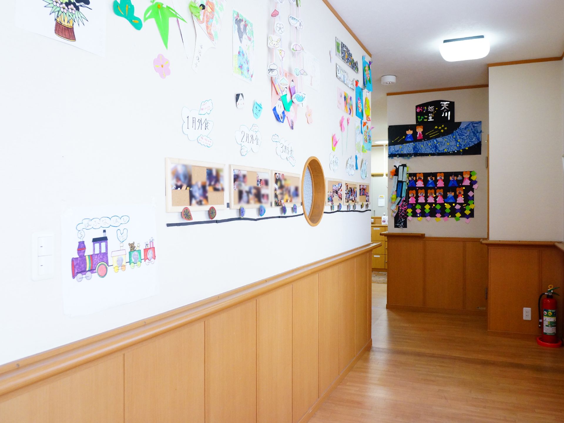 廊下の壁には季節に応じた掲示物、入居者が描いた物や、月々行なわれているレクリエーションの写真が飾られている。