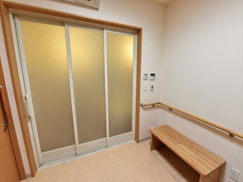 「グループホームひかり世田谷宇奈根」の脱衣所。お風呂上がりの休憩に、木製ベンチを用意している。