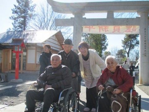 神社にある鳥居の前で写真を撮影するスタッフと入居者様たち