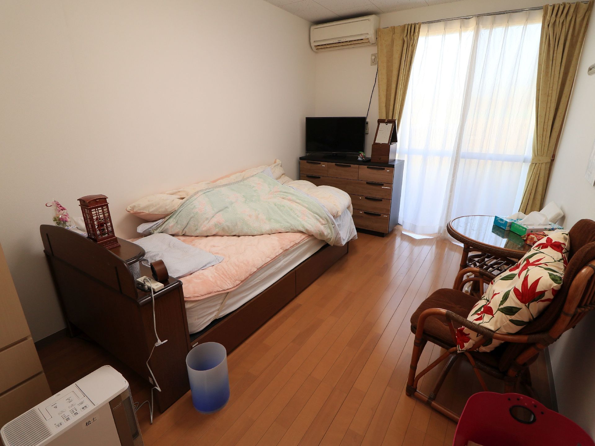 ワンルームタイプの間取りで明るく清潔感がある。壁に家具を寄せて配置しているので、通路が広く確保されている。