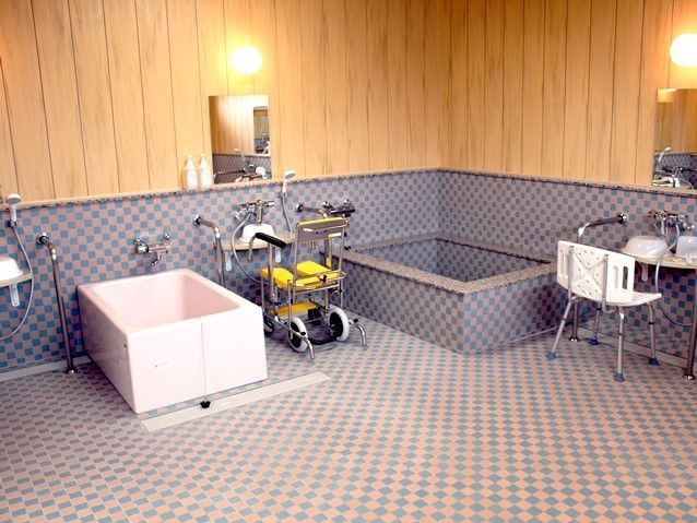 デザイン性のある木のぬくもりが感じられる浴室である。広い洗い場には、シャワーチェアや車椅子が用意されている。