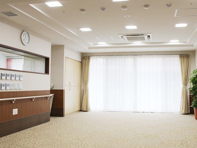 食堂は機能訓練室としても使用することが可能となっている。壁には手すりが設置されており、大きな窓が特徴的。