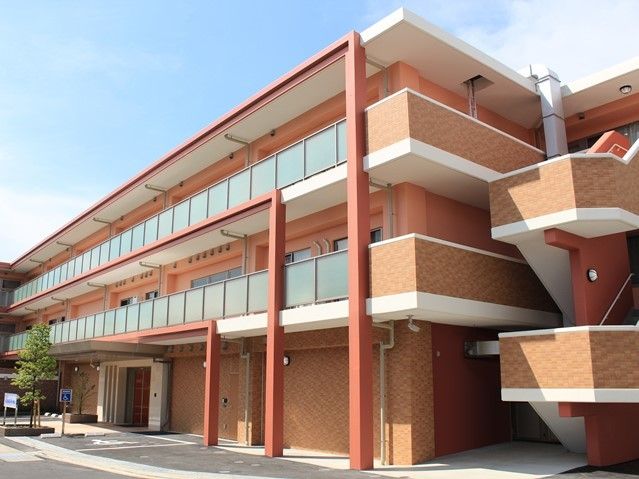 オレンジ色が明るく特徴的な建物となっている。玄関の近くに駐車場があり、段差がないためスムーズに出入りができる。
