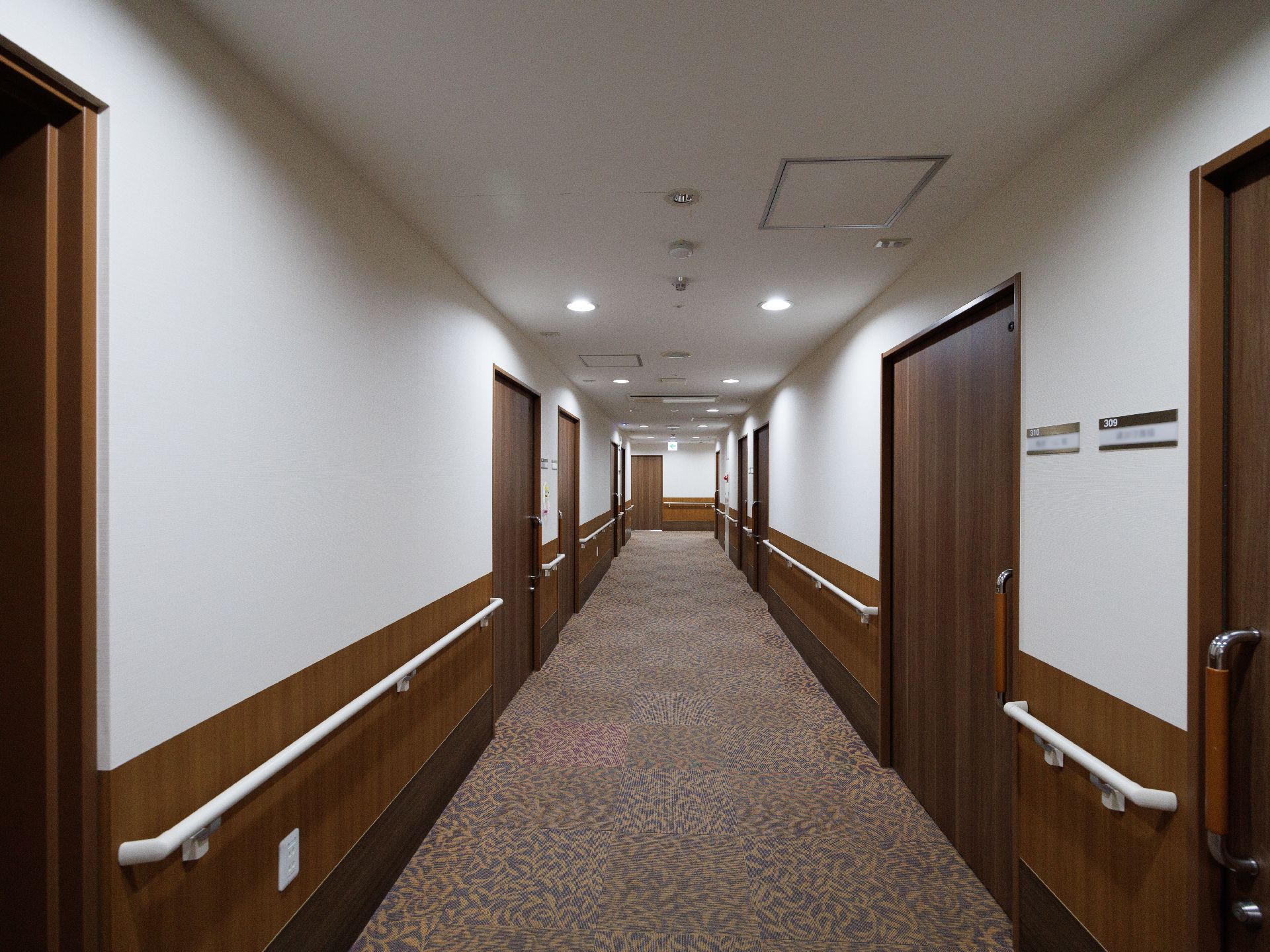 両側の壁に手すりが配置された廊下