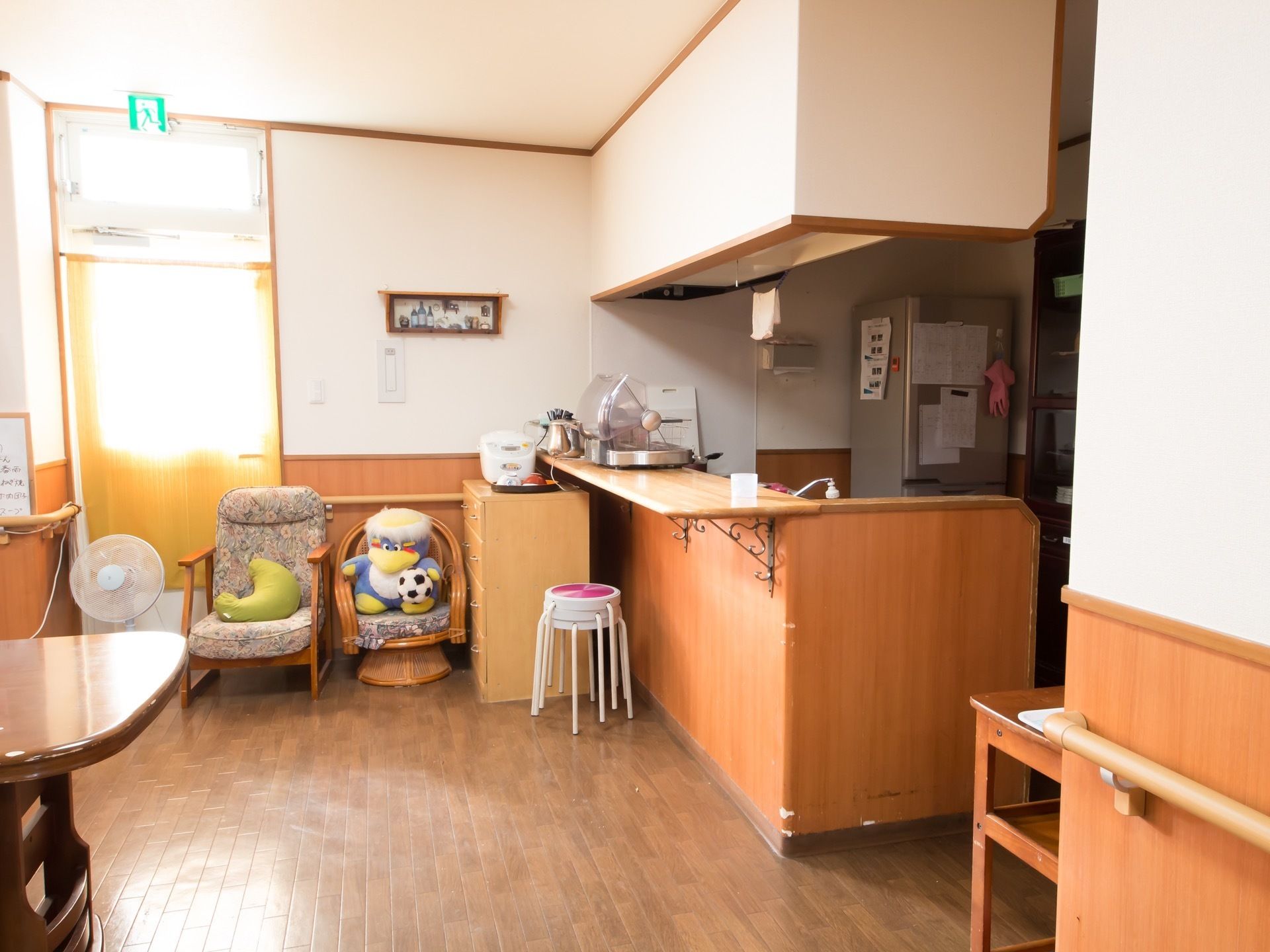 木目調の床であたたかみが感じられる共有スペースである。可愛らしいぬいぐるみも設置されていて、のんびり過ごすことができる。