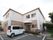 ２階建ての建物で、１階部分はレンガ調の外壁になっている。玄関の前は駐車場になっており、建物の横には自転車が置かれている。