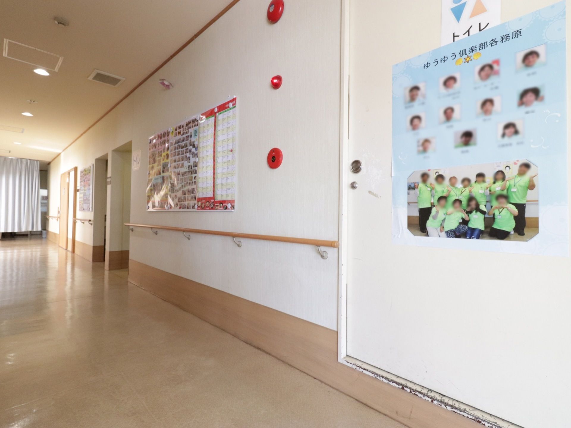 通路の壁には案内掲示などが貼られている。手すりも設置され安全に移動ができ、非常警報装置も完備されている。