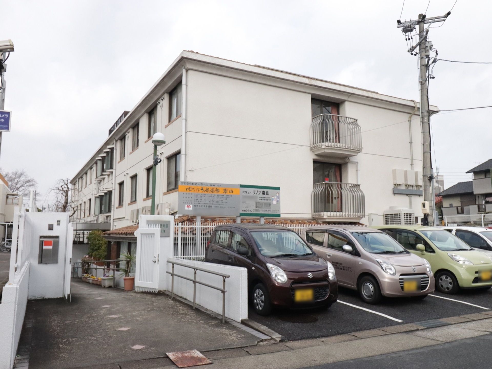 地上３階建てのマンションのような外観。外には駐輪場、来訪者様用に６台分の駐車場も確保している。スロープを通って車椅子をご利用の方も通れる。
