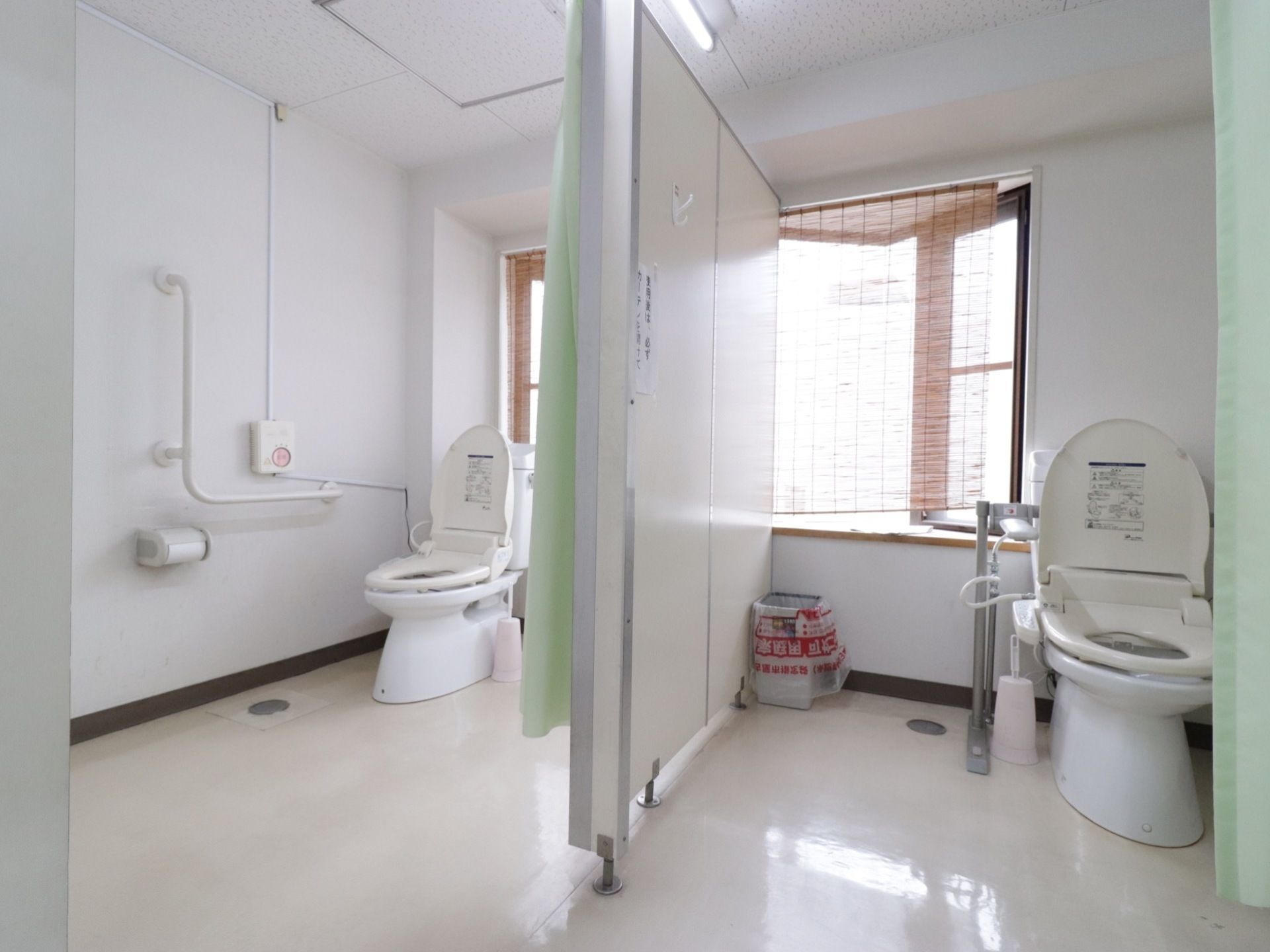 広々しているトイレは温水洗浄付き。手すりが付いて安全に使用できる。緊急用ボタンが大きく取り付けられている。