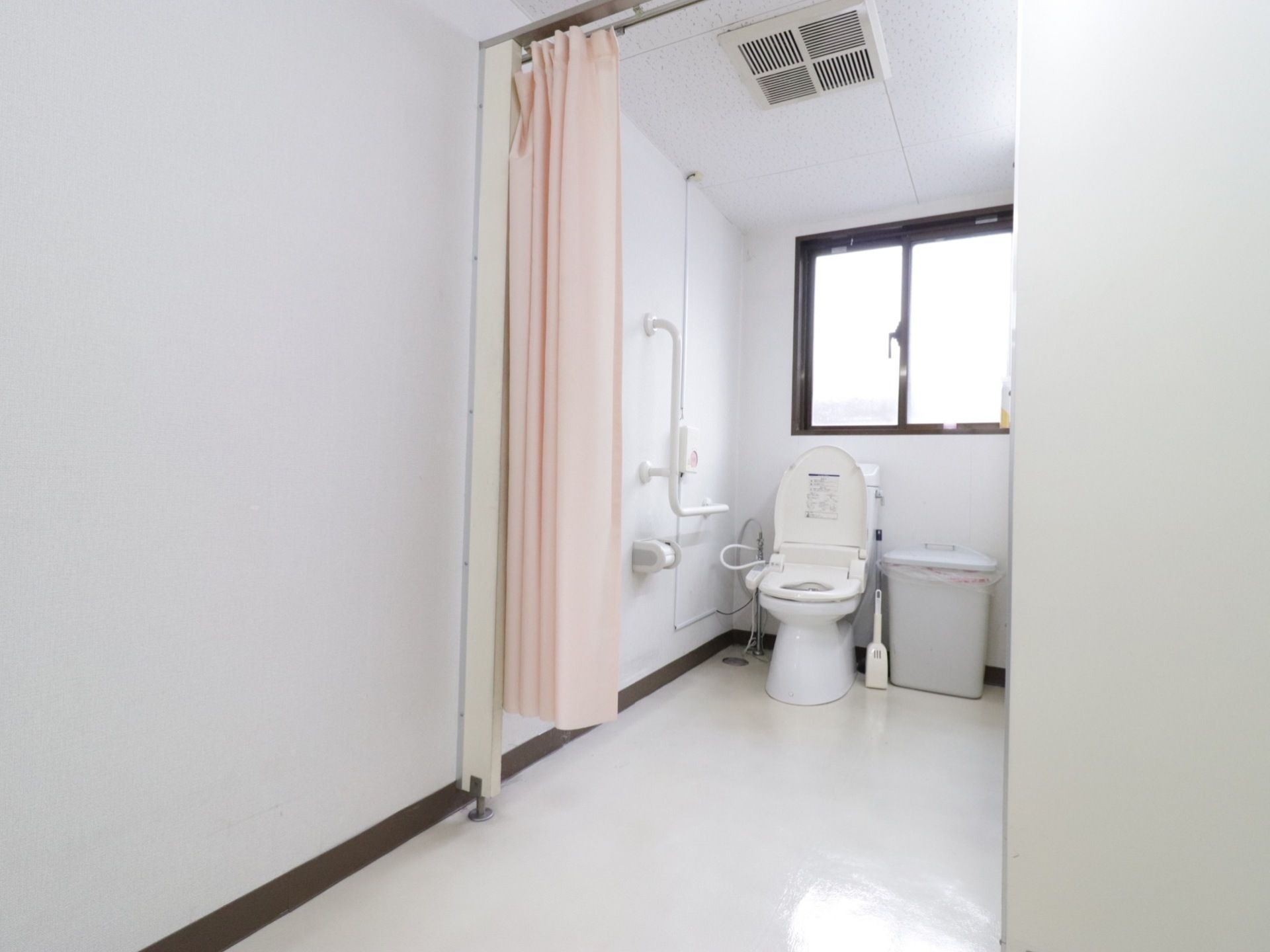 カーテン仕切りのトイレで、車椅子をご利用の方も出入りがスムーズ。広々した空間でゆったり使用することができる。