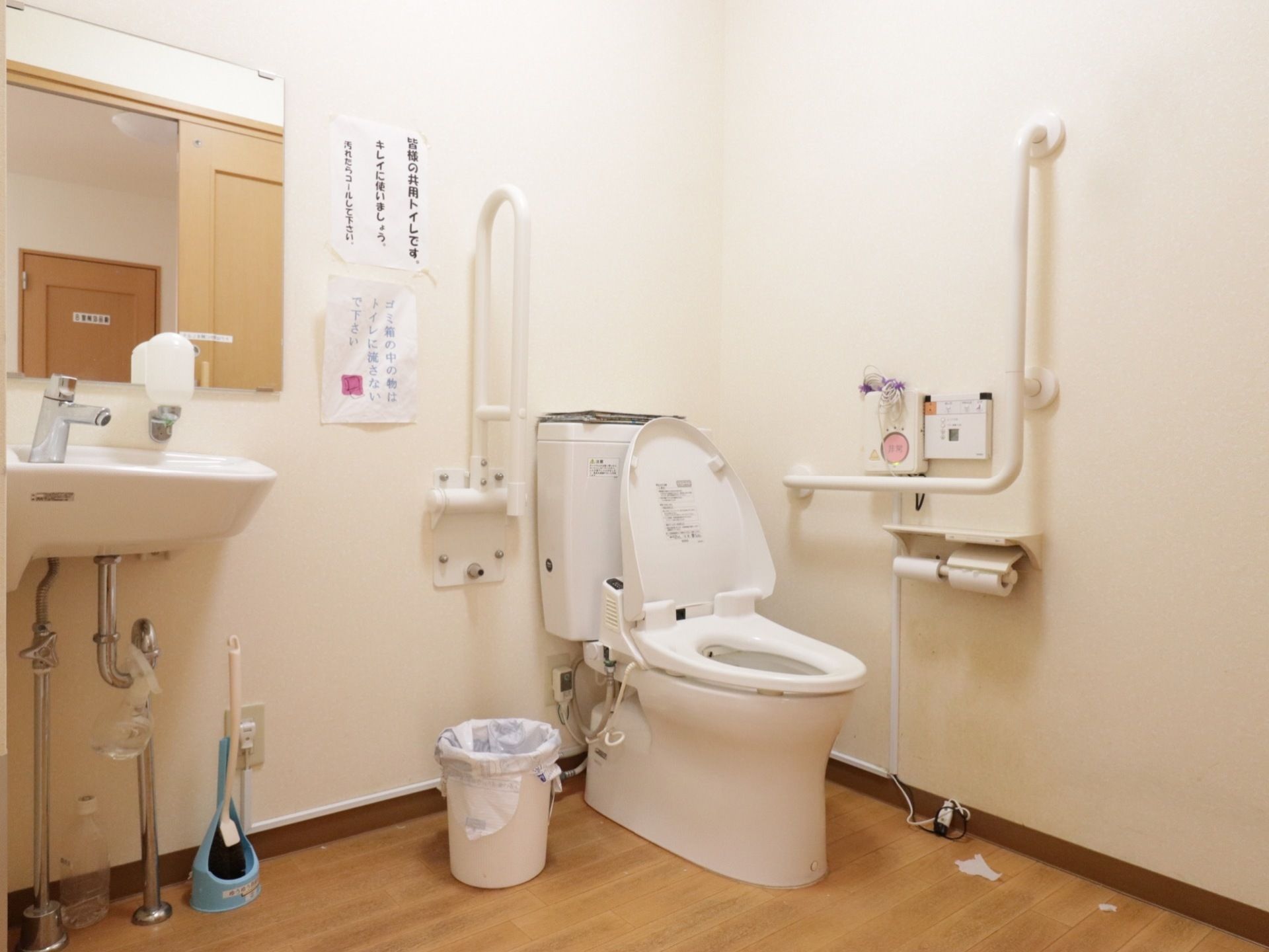 車椅子にも対応している広いスペースの共用トイレである。壁には、可動式やＬ型手すり、洗面台が備え付けられている。