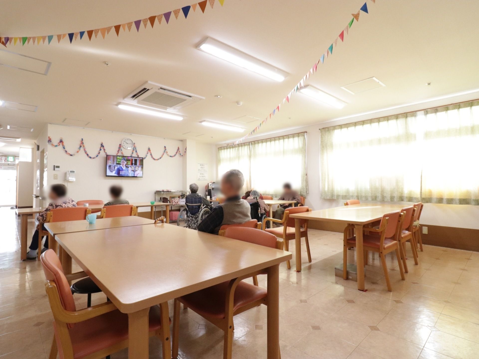 食堂は、明るく開放的な空間になっている。ダイニングテーブルが置かれており、大型テレビが壁に設置されている。