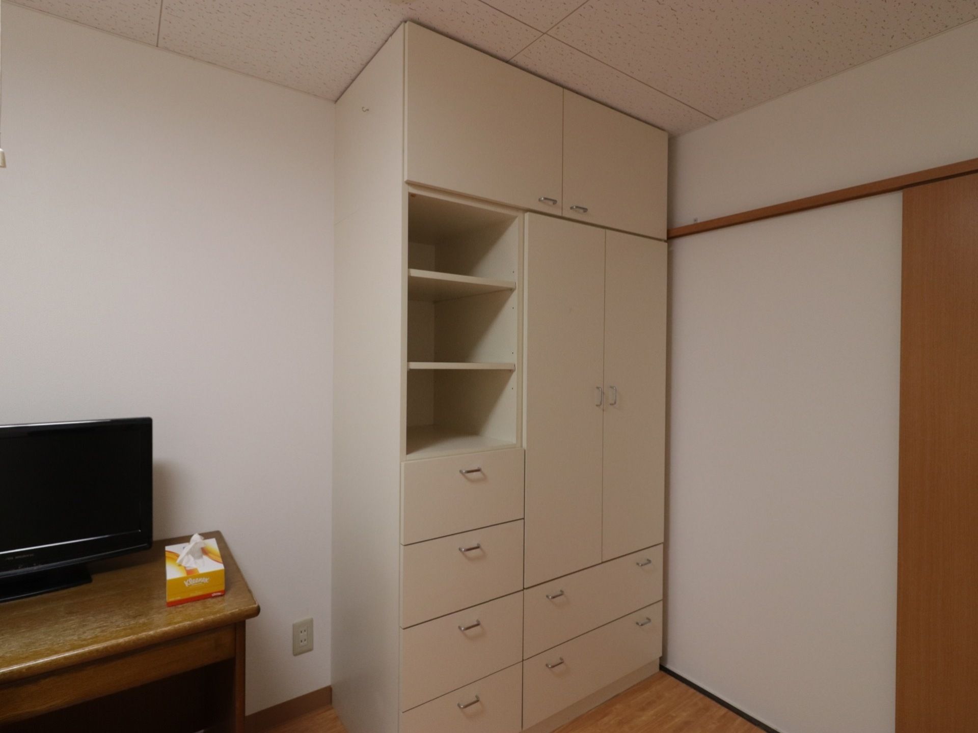 居室には天井まで届く大型の収納が設置されている。棚になっているところや扉が付いたところなど、様々なものを収納することができる。