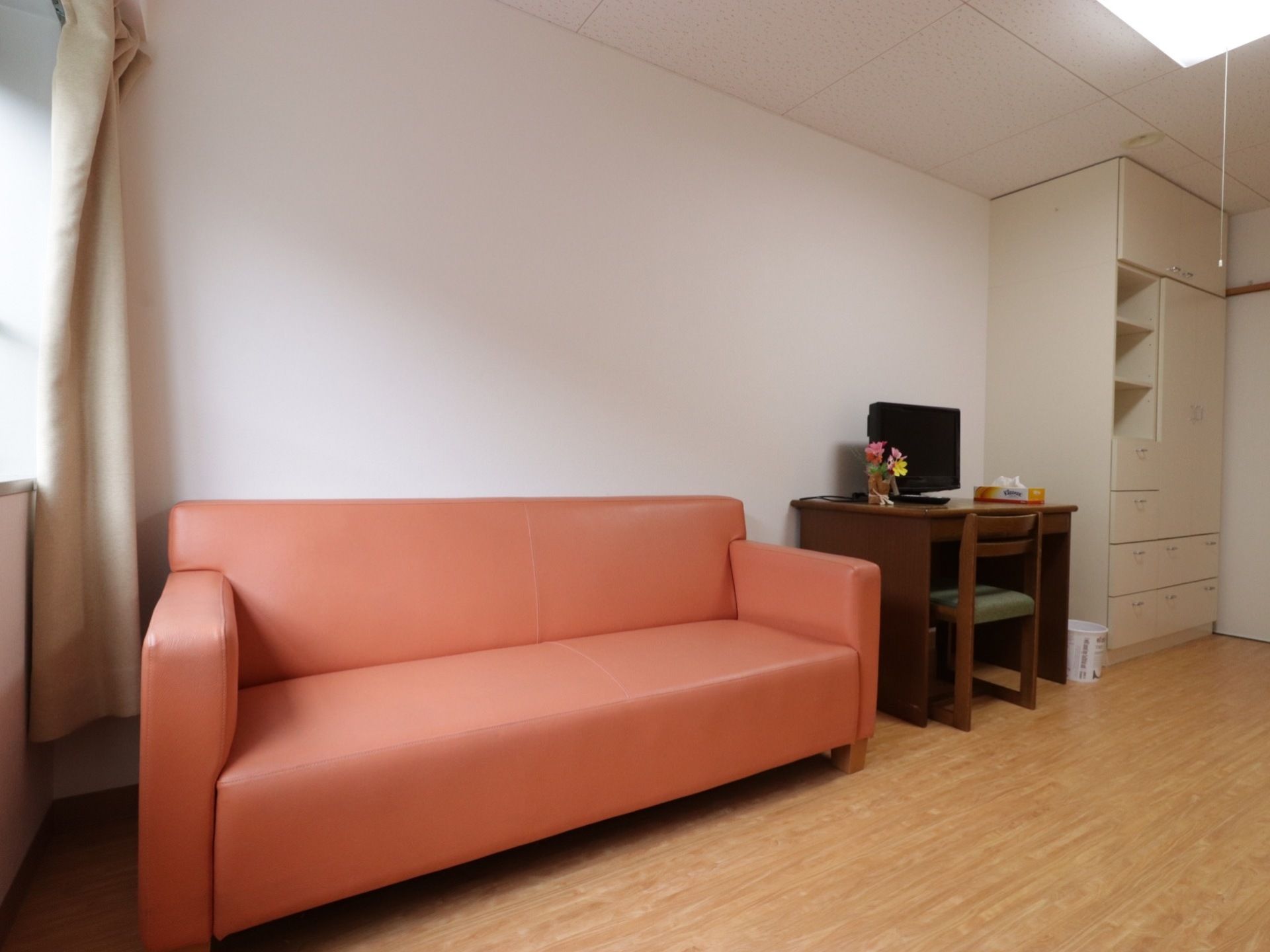 居室にはピンク色の大きなソファーが設置されている。サイズが大きいので、座るだけでなく横になることもできる。
