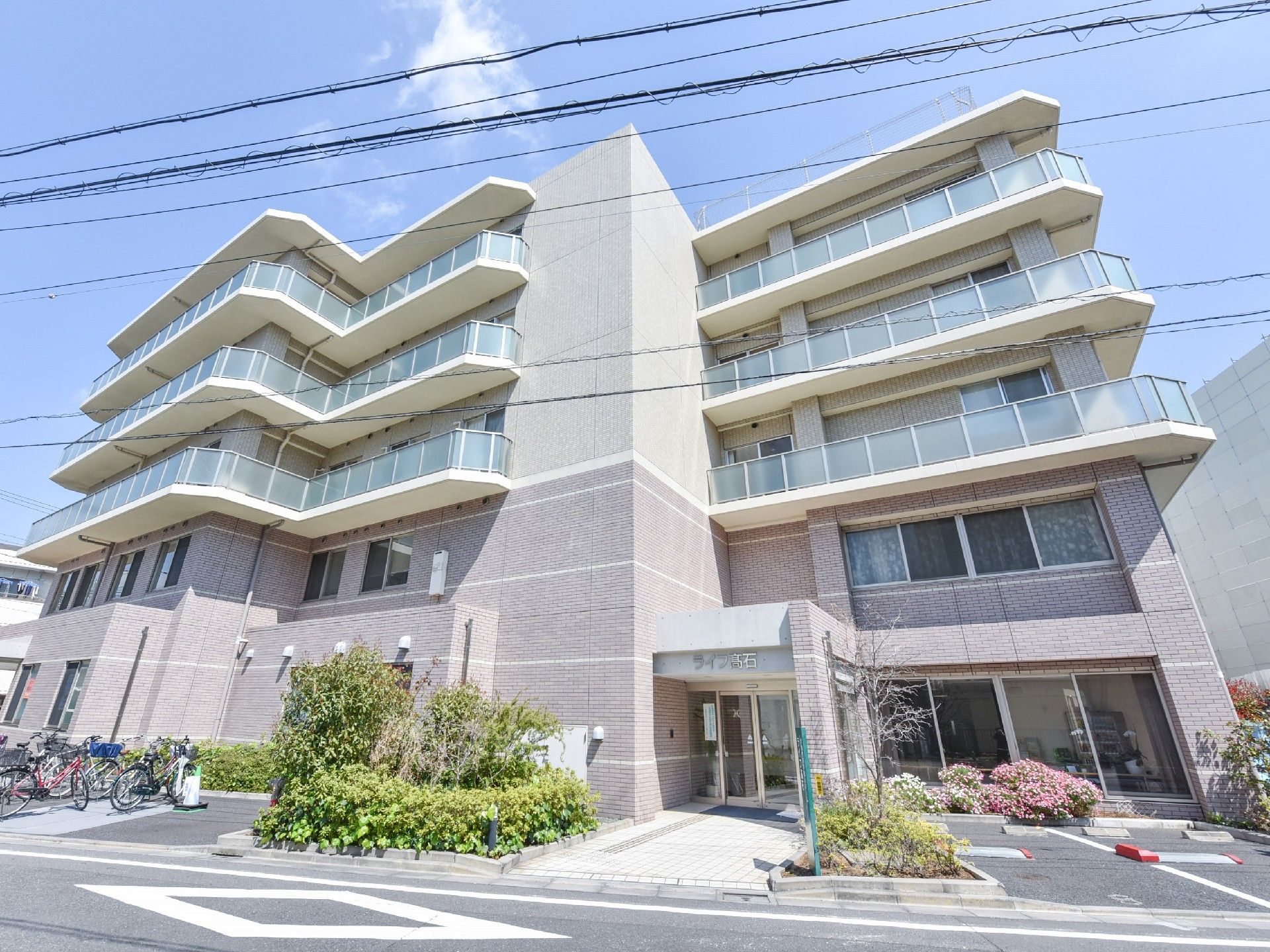 マンションのような大きな建物。ベランダの曇りガラスが水色でとてもきれい。