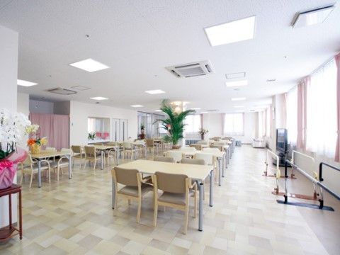 窓際に平行棒が置いてあり、部屋にずらりとテーブルと椅子が並んでいる食堂
