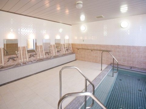 明るい基調の、広々した浴場。湯舟には、手すりや、段差もついており、入りやすいよう安全面が考慮されている。