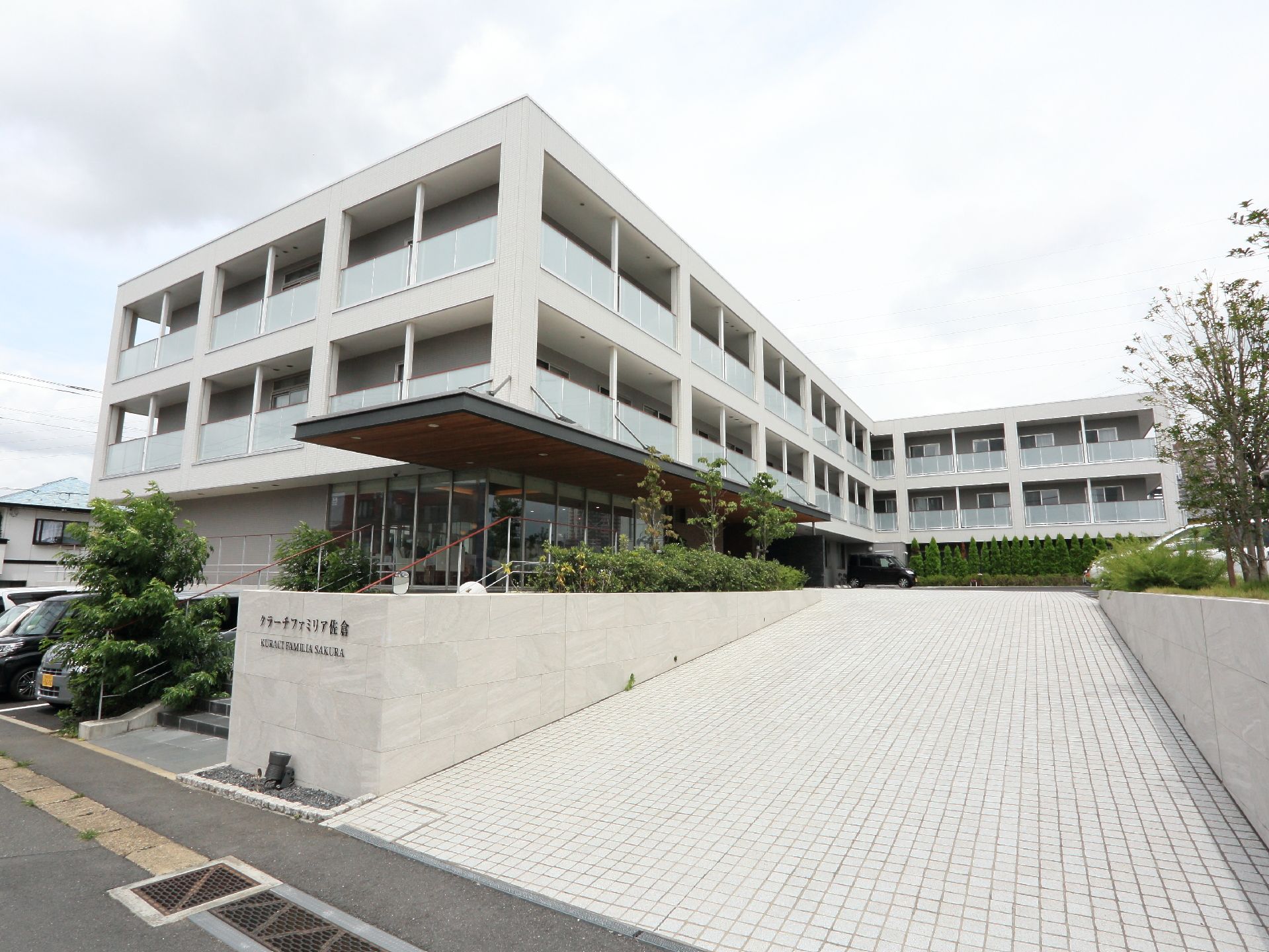 道路沿いに建てられている3階建ての施設の外観。道路からのアプローチはなだらかなスロープ状の坂になっている。