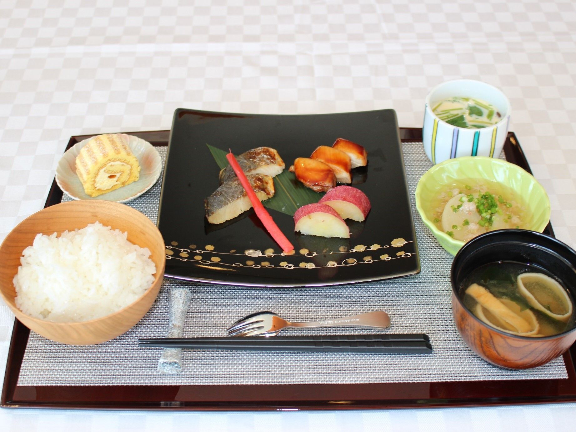 トレイの上にご飯や汁物、副菜を盛り付けたお皿が並ぶ食事