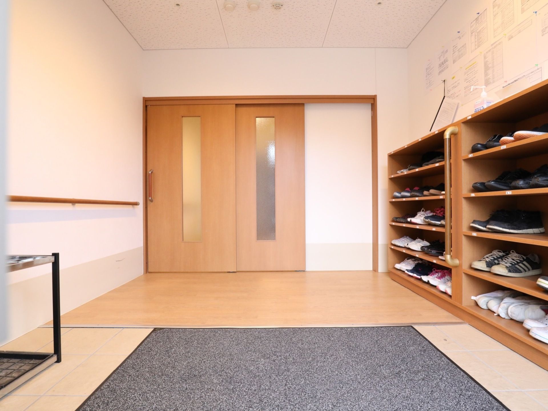 玄関内は風除室になっている。左側には傘立てがあり、右側には木製で手すり付きの入居者用靴箱が設置されている。