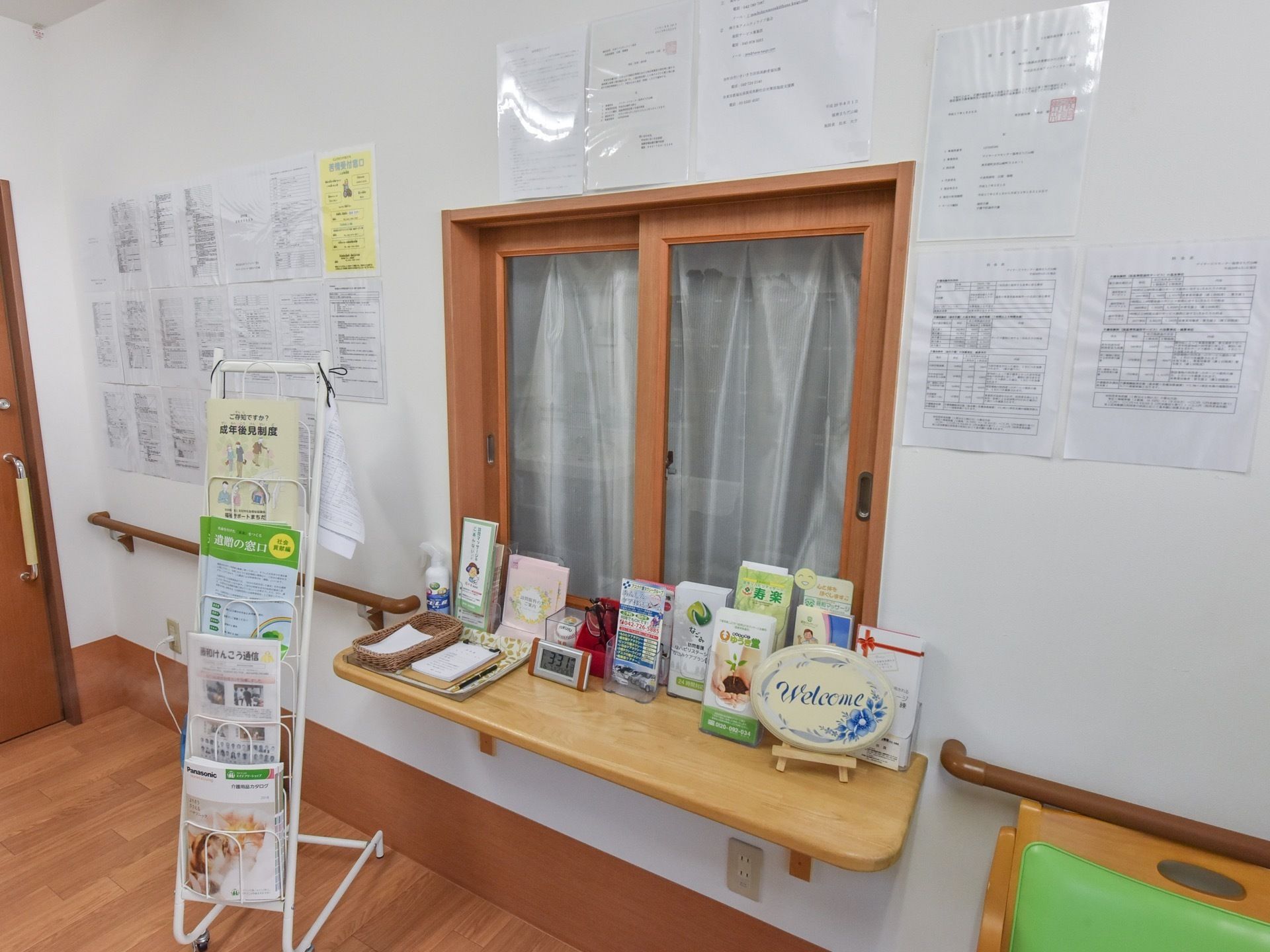 木製の窓枠とカウンターが柔らかな印象の受付。カウンター上の冊子は手に取りやすいように、スタンドにセットされている。
