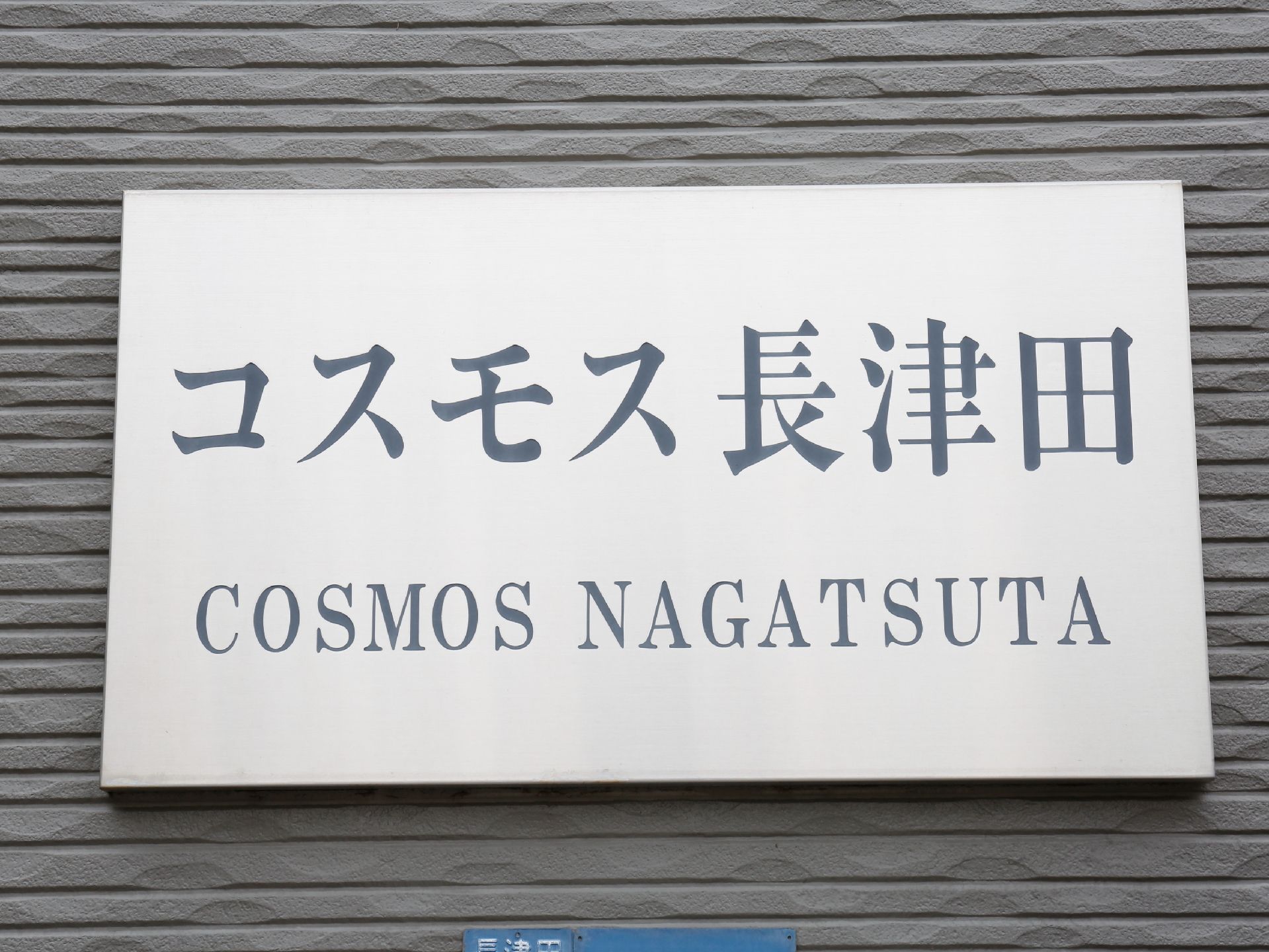 エントランスには施設名が書かれた看板が取り付けられている。名称の文字は日本語の他に、ローマ字でも表記されている。