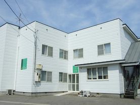白い壁の2階建ての建物である。周りに高い建物もなく、日当たりが良い。玄関にはスロープがあり、安全に利用できる。