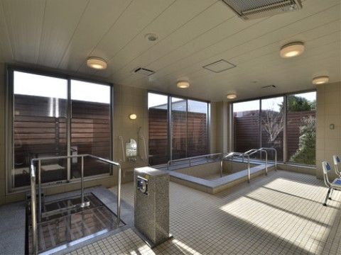 広々とした大浴場の側面はガラス張りになっている。湯船への出入りが安全に行えるように、浴槽には手すりを完備している。