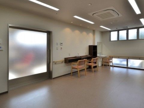 中央スペースは、何も置かれていない広々とした空間である。天井に細長い照明を間隔を置いて設置している。壁際に備えた台の傍に椅子を置いている。