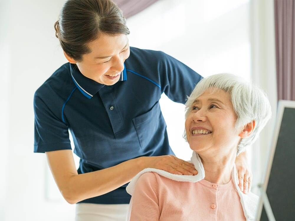 ナースステーションの前でカルテを持ち微笑んでいる二人の看護師
