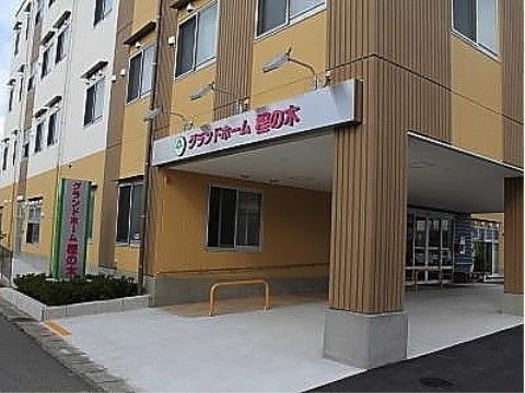 大きな車寄せが玄関前にあり、看板の上に照明がついている建物