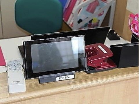 カウンターの上に置かれた事務用品、電話の子機とタブレット