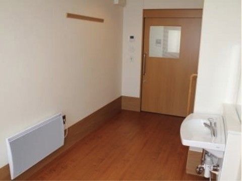 大きな扉なので出入りが安心。パネルーヒーターを設置するなど快適な生活を送るための考慮している。白い洗面台は清潔感がある。