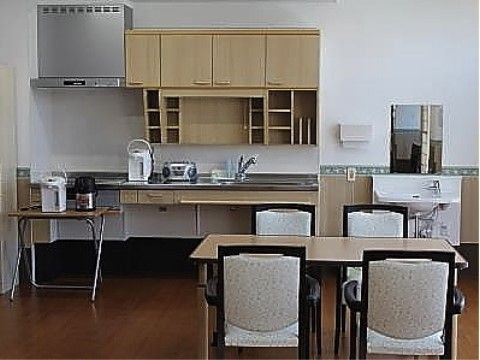 キッチンの流し台部分には、手すりがついているので、安心して使用できる。キッチンのすぐ隣には洗面台と鏡が設置してある。
