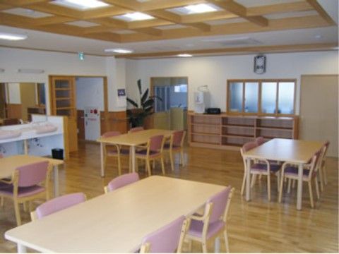大きな鏡のついた洗面台や棚が置いてあり、等間隔にテーブルと椅子が並んだ食堂