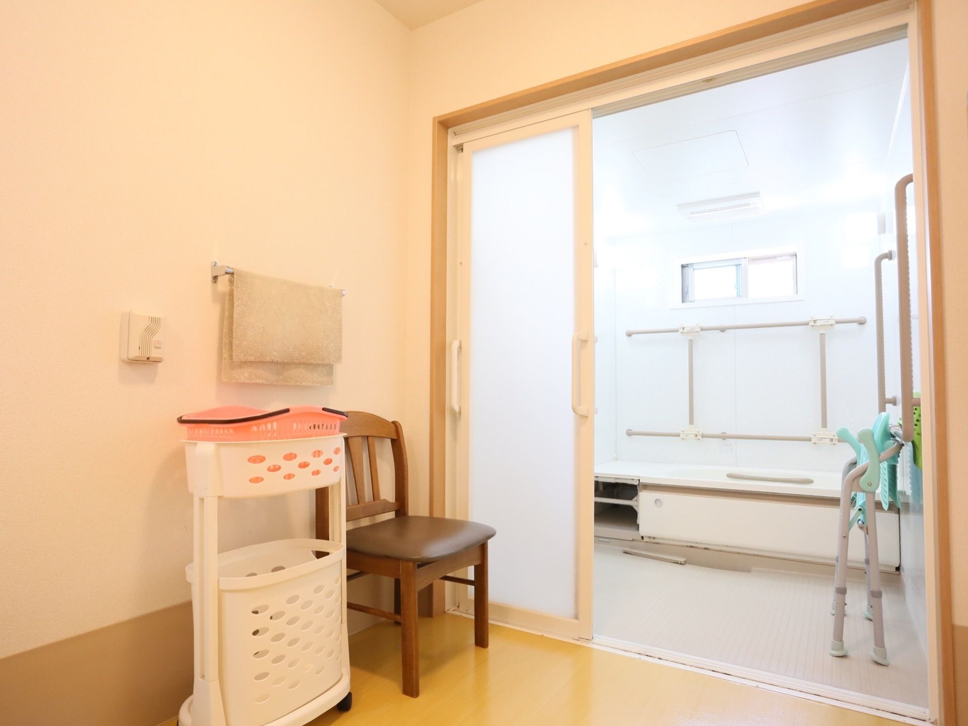 浴室の出入り口には大きく開く引き戸を採用している。内部には大型の浴槽を設置し、壁に手すりを取りつけている。