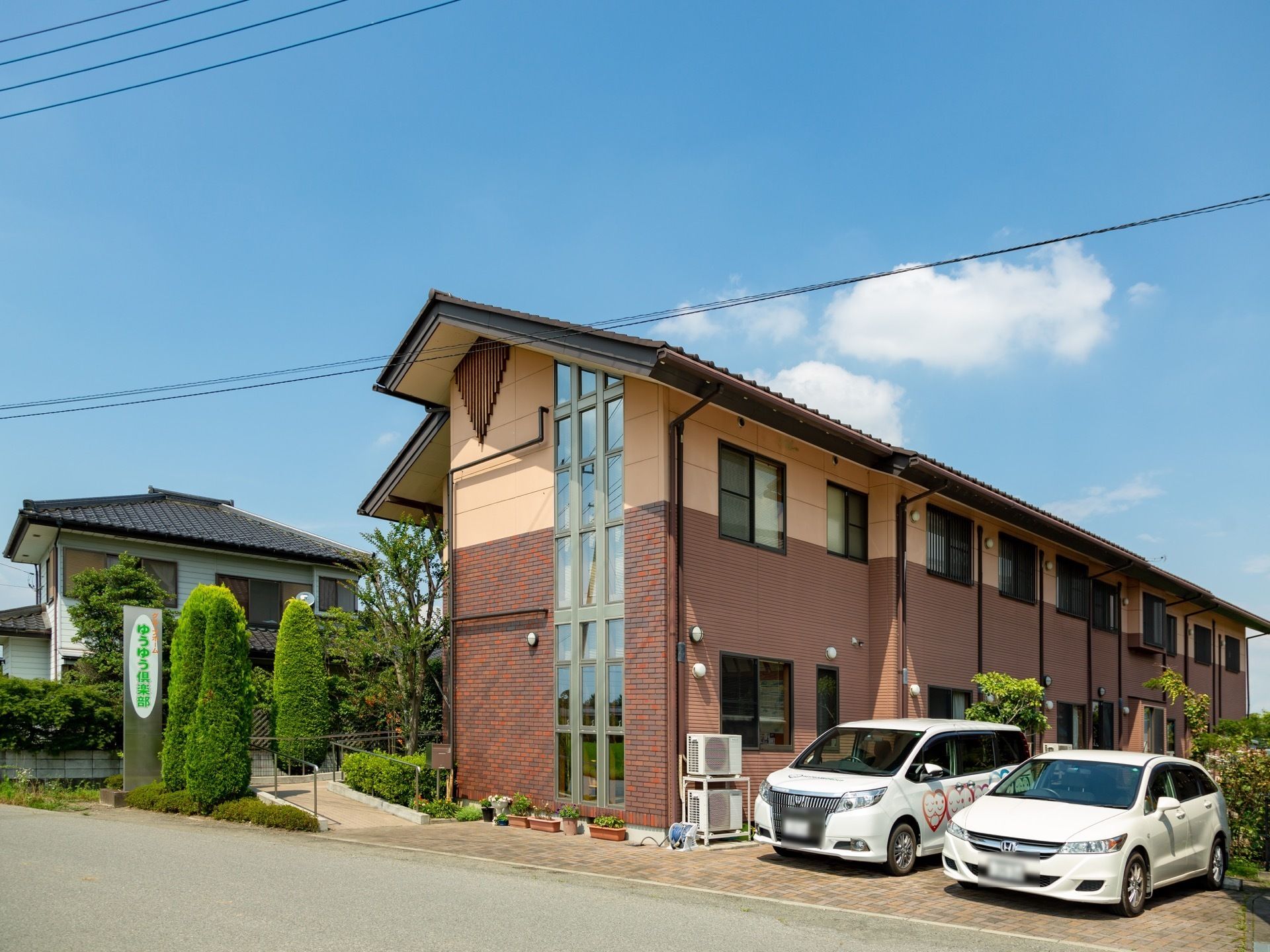 施設外観はおしゃれなデザイナーズ建築のようで、暖色系のツートンカラーが印象的。施設周辺は植物で囲まれ、緑の柵になっている。
