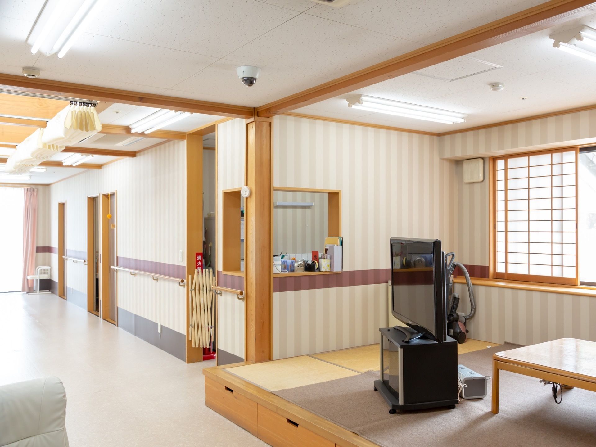 開放的なリビングには、小上がりになっている和室スペースが設けられており、キッチンが併設されている。テレビや座卓が置かれている。