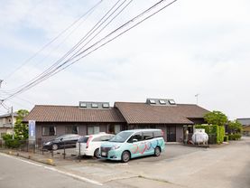 一階建ての長屋構造で、窓が多いデザインをしており、優しい印象となっている。車６台分の駐車場も設置されている。