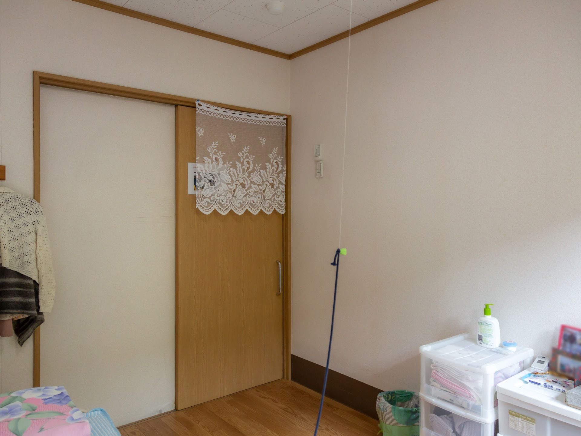 木の床が敷かれ、白い壁に囲まれた居室である。電灯の紐は長く垂れており、立たずとも楽に引けるようになっている。