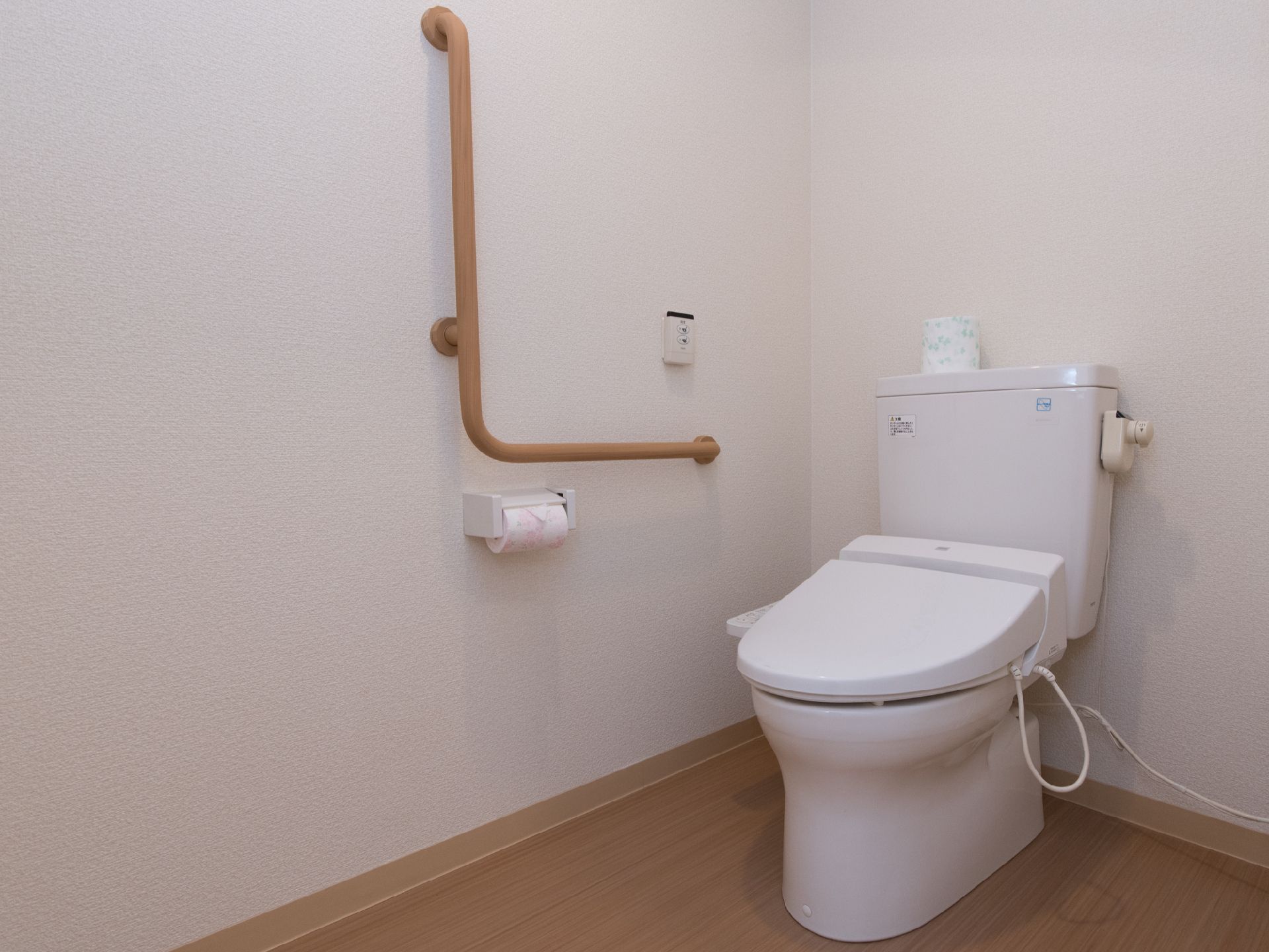 トイレの壁には手すりやナースコールが設置されている。また、便座のタンク上には、予備のペーパーが置いてある。