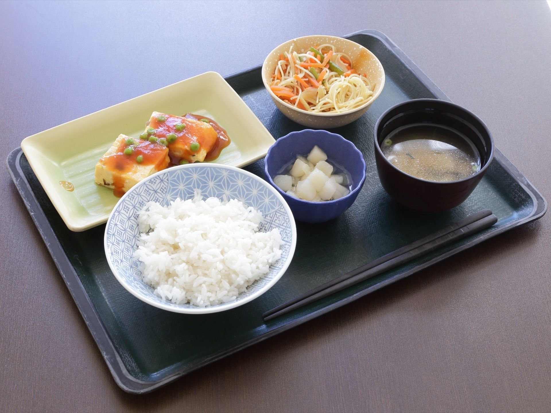 黒いトレーの上には、5つの器に盛られた食事が並べられている。ご飯とお味噌汁を中心に豆腐や野菜などのヘルシーなメニューとなっている。