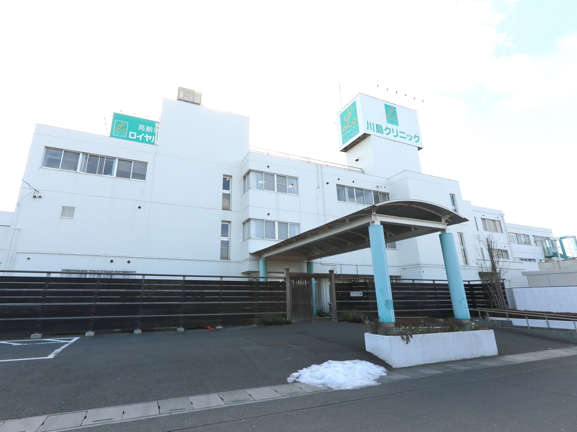 施設は三階建ての白い建物である。玄関前には大型の屋根と門を設置し、前面には広い駐車スペースを設けている。