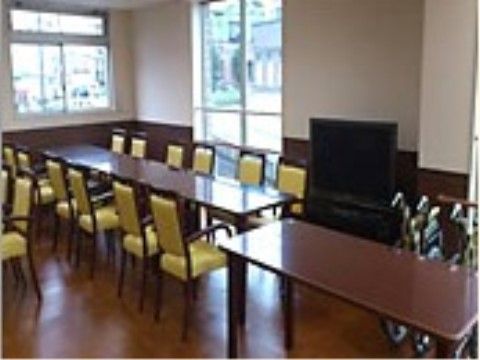 細長いテーブルと椅子が並べられている、テレビのある食堂