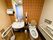 トイレの便座は縦長となっており、ゆったりと腰を掛けられる状態になっている。便座のサイド部分や手洗い場のすぐ横に手すりがある。