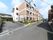 横長の施設となっており、奥まで建物が伸びている形となっている。手前には電柱が建っており、奥にはバイクが停まっている。