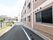 施設の外にある道路は、出口に向かって緩やかなスロープ状になっている。道路の端には緑が植えられ、柵もある。