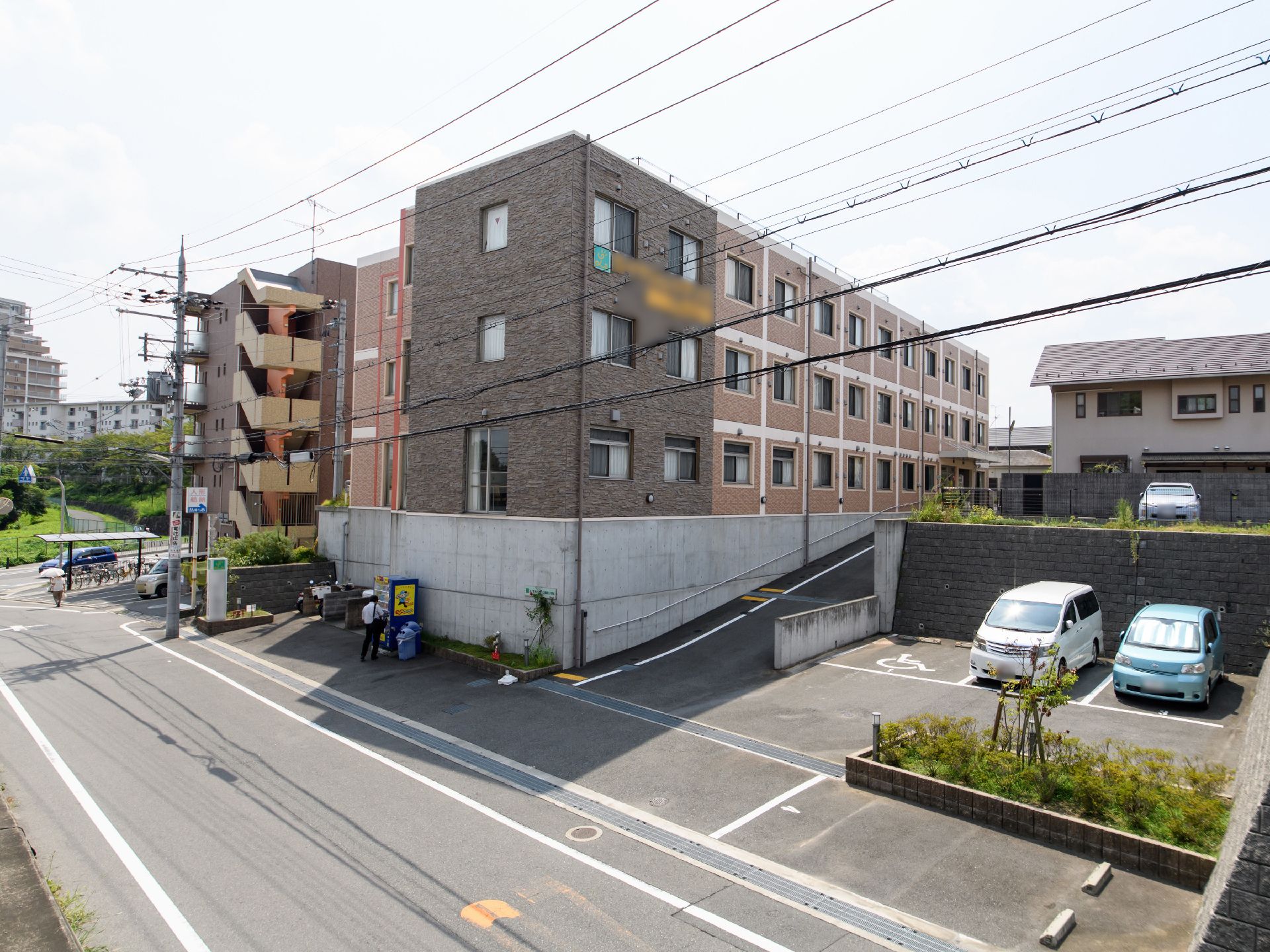 施設の全体が写っており、2階と3階の間の部分には金色になっている施設名の看板が貼り付けられた状態となっている。