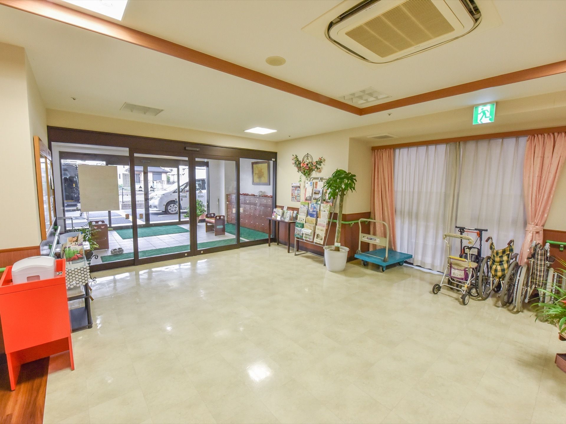 風除室のある正面エントランスの上には誘導灯がなく、その脇にあるドアがランプの付いた緊急時の非常口になっている。